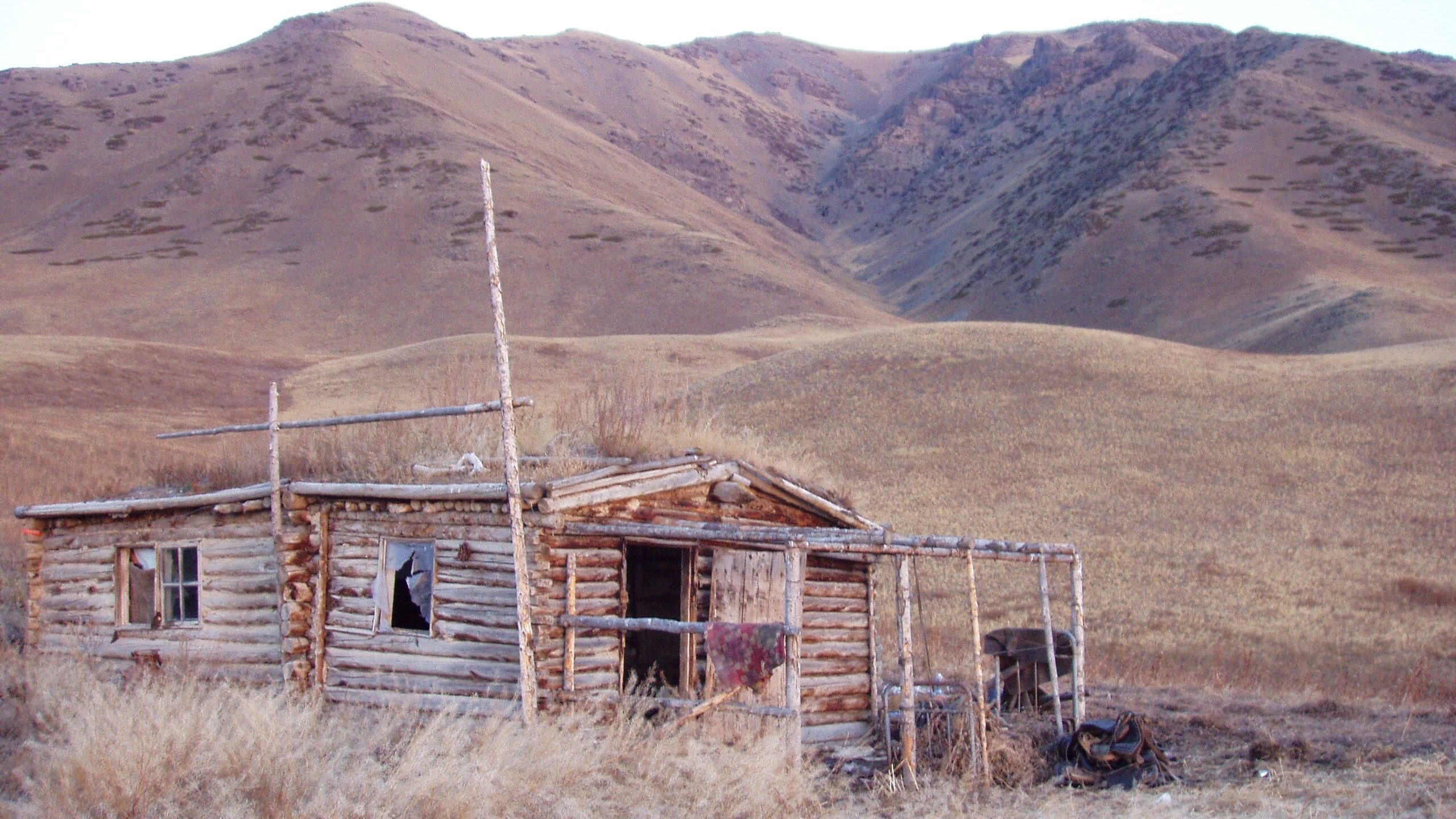 Abandoned log cabin in the Kazakh steppe at golden hour